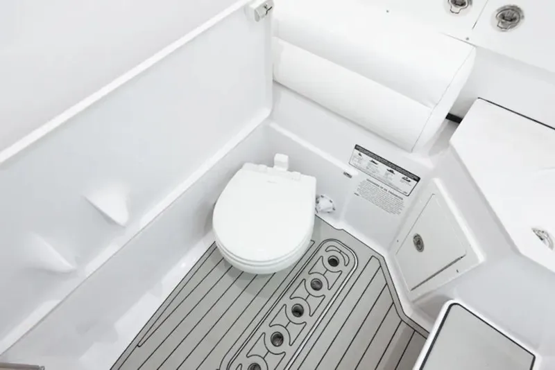 Slide: The Image of 2026 Sportsman Open 302 Center Console boat bathroom interior with modern toilet and storage. - 5