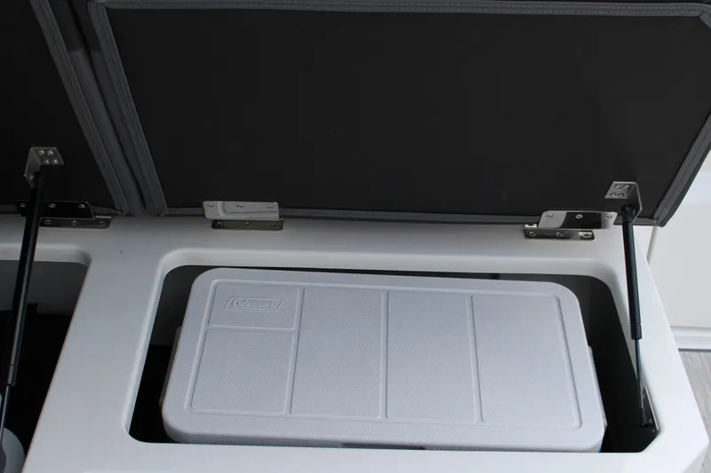Slide: The Image of Open storage compartment in 2025 Cobalt R33 boat with a Coleman cooler inside. - 15