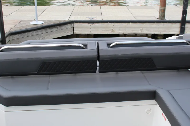 Slide: The Image of 2025 Cobalt R33 boat seating with sleek gray upholstery and quilted design by the dock. - 16