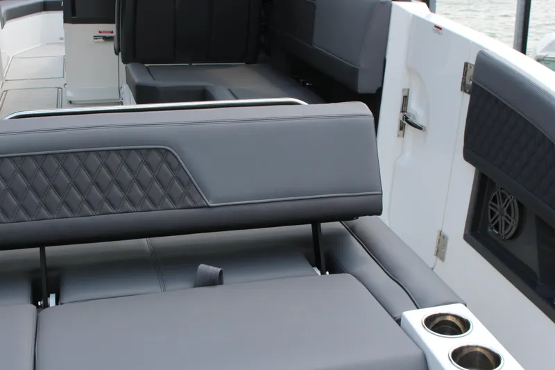 Slide: The Image of 2025 Cobalt R33 boat interior with gray leather seating and cup holders. - 18