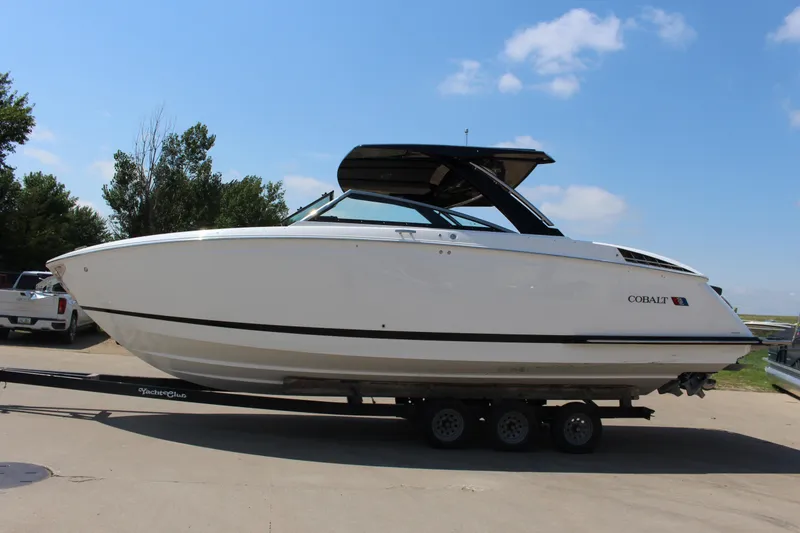 Slide: The Image of 2025 Cobalt R33 boat on trailer under clear blue sky. - 36