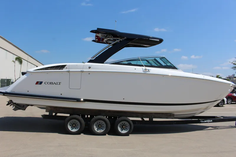 Slide: The Image of 2025 Cobalt R33 boat on trailer, side view, under clear blue sky. - 40