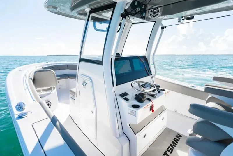 Slide: The Image of 2026 Sportsman Open 282 boat interior with steering console, on a sunny ocean backdrop. - 11