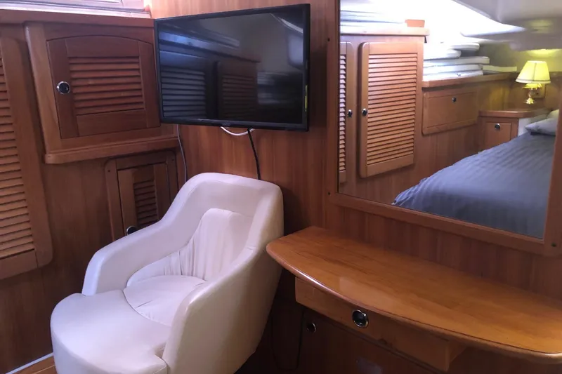 Slide: The Image of Interior of 2000 Catalina 470 yacht with chair, TV, and wooden cabinetry. - 11