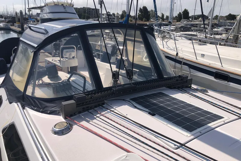 Slide: The Image of Catalina 470 sailboat, 2000 model, featuring a solar panel and cockpit enclosure in a marina. - 17