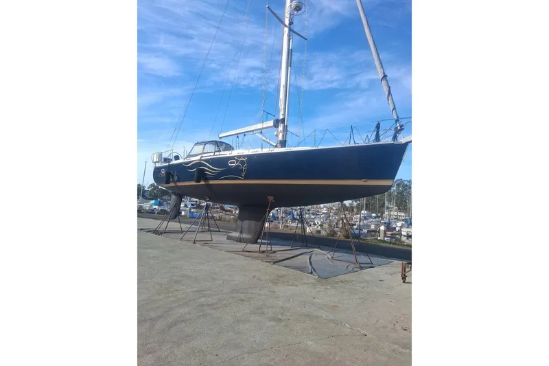 Slide: The Image of Catalina 470 sailboat from 2000 on dry dock, blue hull, clear sky background. - 29