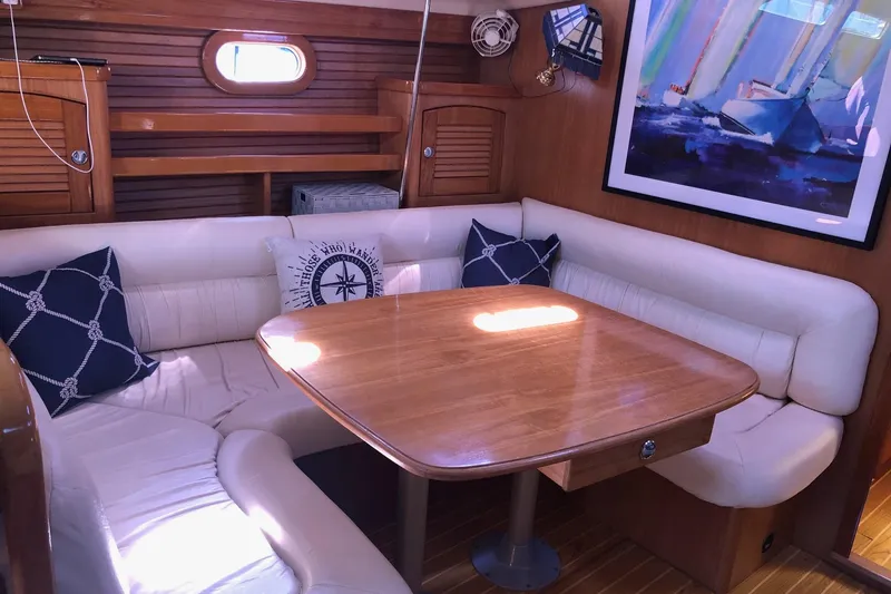 Slide: The Image of Cozy interior of 2000 Catalina 470 yacht with wooden table and cushioned seating. - 3