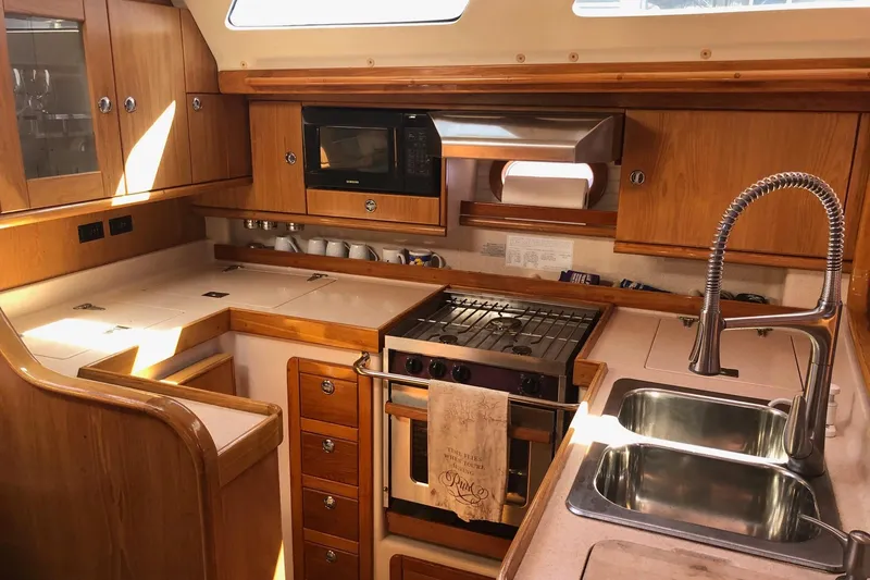 Slide: The Image of Interior of 2000 Catalina 470 yacht kitchen with wood cabinetry and modern appliances. - 6