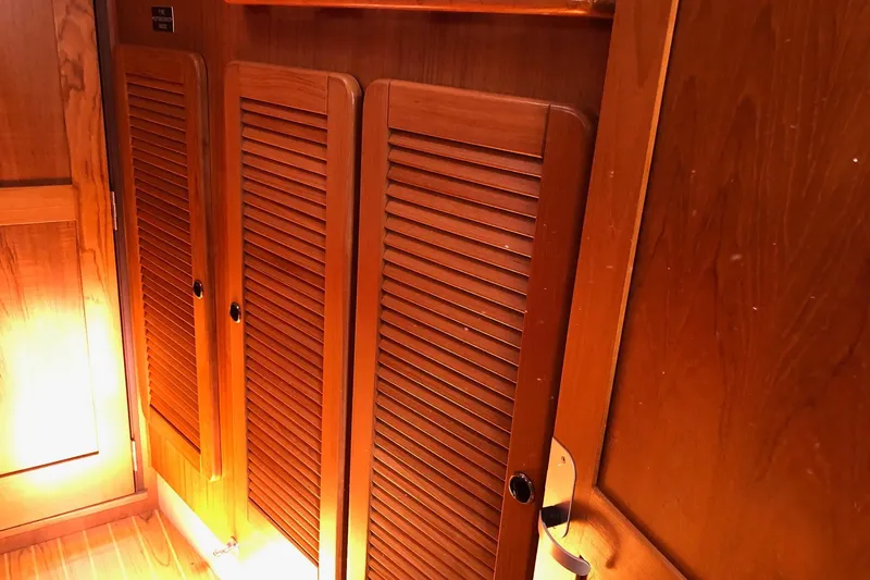 Slide: The Image of Wooden interior of a 2000 Catalina 470 sailboat, featuring louvered cabinet doors. - 8