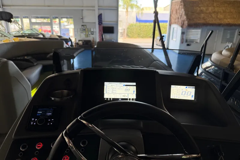 Slide: The Image of 2024 Bennington 23 RSB boat dashboard with digital displays and steering wheel in showroom. - 19