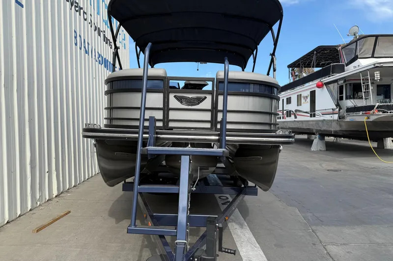 Slide: The Image of 2024 Bennington 23 RSB pontoon boat on trailer, dockside view. - 2