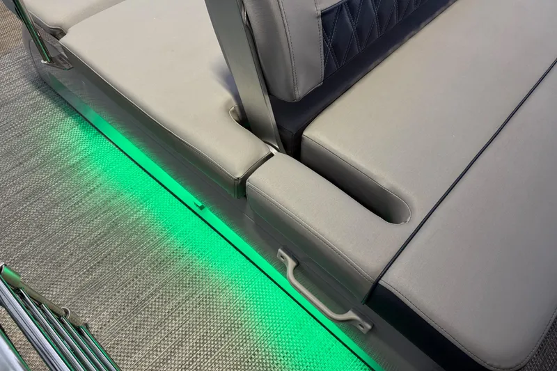 Slide: The Image of 2024 Bennington 23 RSB boat interior with green LED lighting and cushioned seating. - 26
