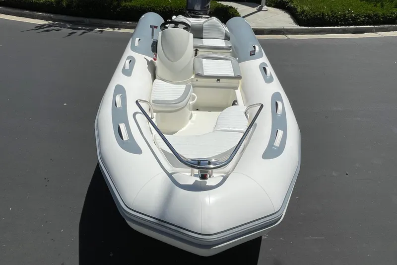 Slide: The Image of 2007 Zodiac Yachtline Deluxe 420 inflatable boat, white with seating, parked on pavement. - 18