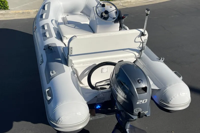 Slide: The Image of 2020 Achilles HB-315DX inflatable boat with Yamaha 20HP outboard motor, parked on pavement. - 12