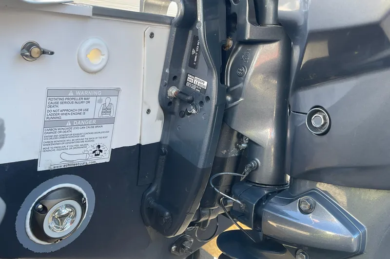 Slide: The Image of Close-up of Achilles HB-315DX boat engine, showing warning labels and mechanical components. - 17