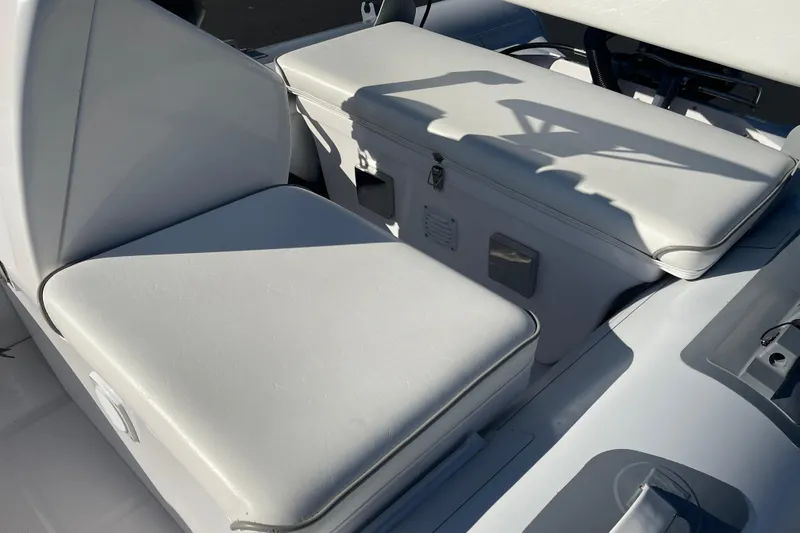 Slide: The Image of Interior seating of 2020 Achilles HB-315DX boat, featuring cushioned white seats. - 4