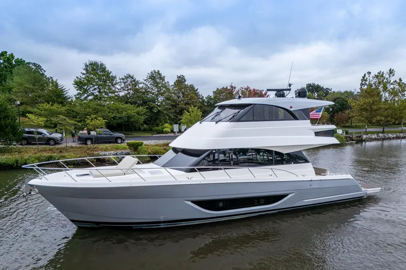 The Image of 2023 Maritimo M55 yacht on a serene river with lush greenery. - 0