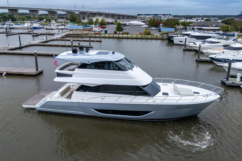 Slide: The Image of 2023 Maritimo M55 yacht docked in a marina, showcasing sleek design and modern features. - 10