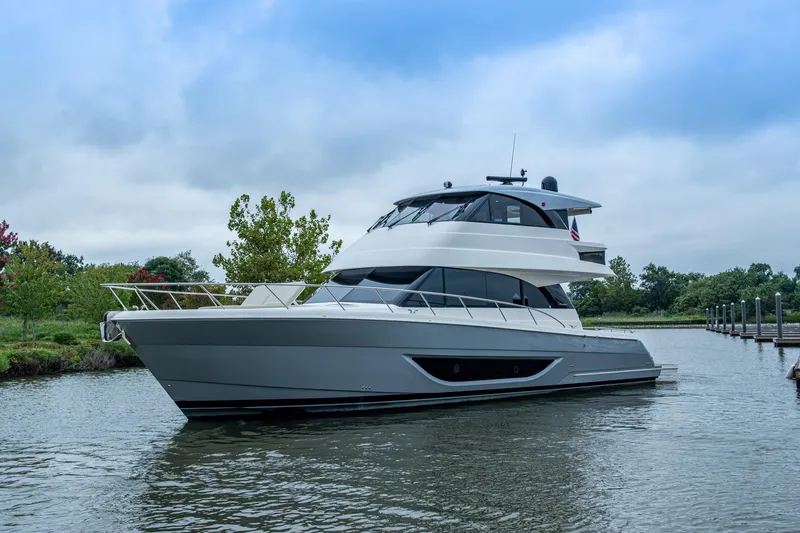 Slide: The Image of 2023 Maritimo M55 yacht on a serene waterway, surrounded by lush greenery. - 106