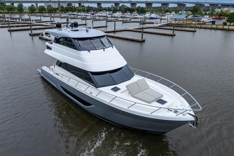 Slide: The Image of 2023 Maritimo M55 luxury yacht cruising in a marina, showcasing sleek design and spacious deck. - 12