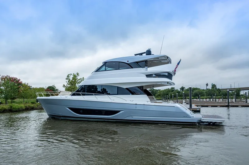 Slide: The Image of 2023 Maritimo M55 yacht cruising on a calm river near a marina. - 123