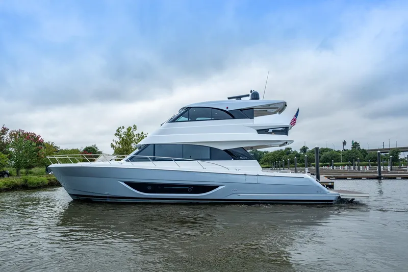 Slide: The Image of 2023 Maritimo M55 yacht on water, sleek design, overcast sky, dock in background. - 124