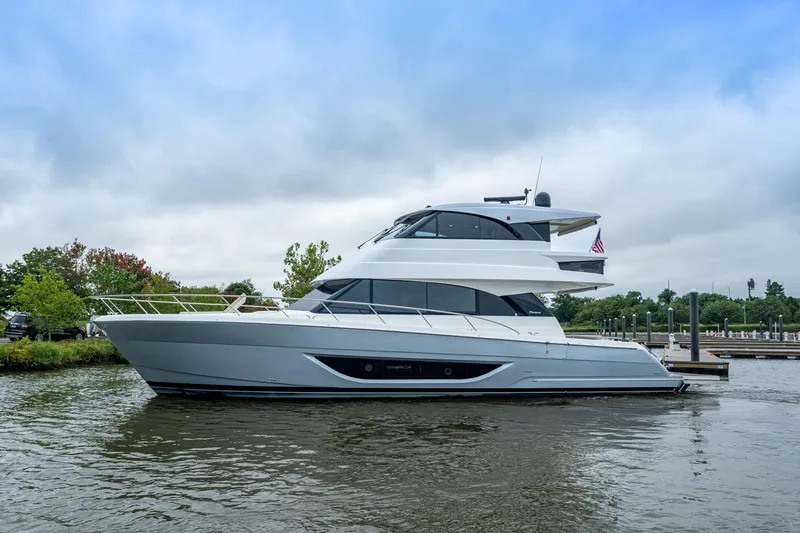 Slide: The Image of 2023 Maritimo M55 yacht docked on a calm waterway under a cloudy sky. - 125