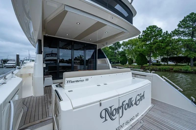 Slide: The Image of 2023 Maritimo M55 yacht docked, featuring sleek design and spacious deck area. - 133