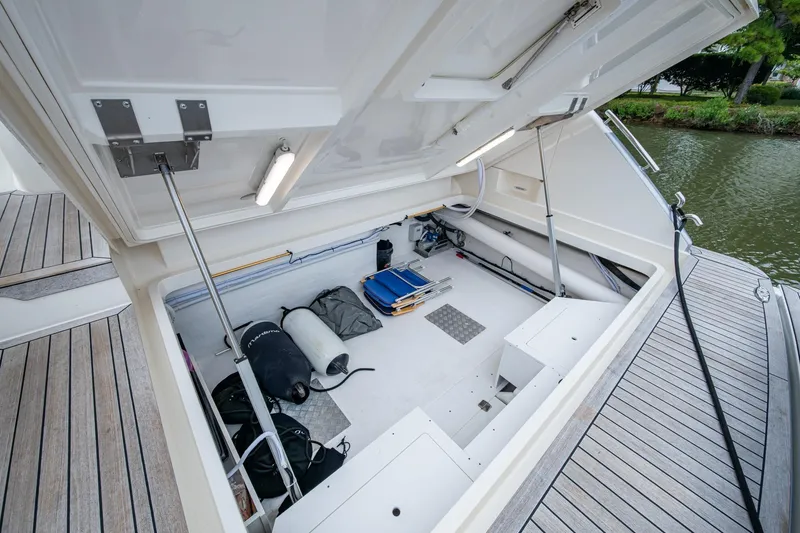 Slide: The Image of Open storage compartment on 2023 Maritimo M55 yacht, featuring various equipment and gear. - 137