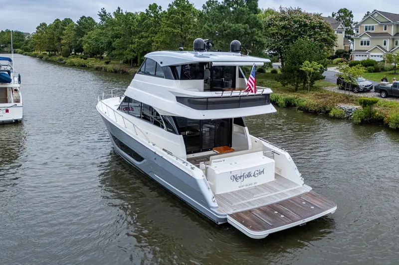 Slide: The Image of 2023 Maritimo M55 yacht cruising on a scenic river with lush greenery. - 5