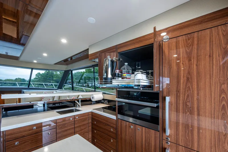 Slide: The Image of Luxurious 2023 Maritimo M55 yacht kitchen with modern wood cabinetry and sleek appliances. - 58