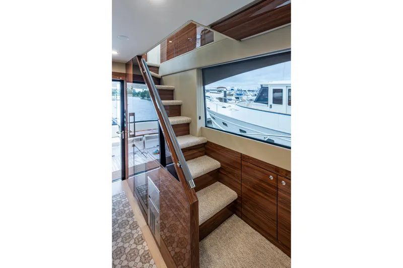 Slide: The Image of Interior of 2023 Maritimo M55 yacht with elegant wooden staircase and marina view. - 62