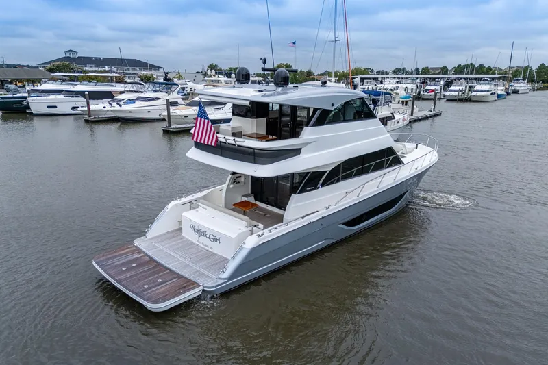 Slide: The Image of 2023 Maritimo M55 yacht docked in a marina, featuring sleek design and American flag. - 7