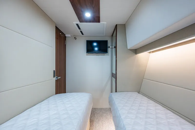 Slide: The Image of Luxurious 2023 Maritimo M55 yacht cabin with twin beds and wall-mounted TV. - 74