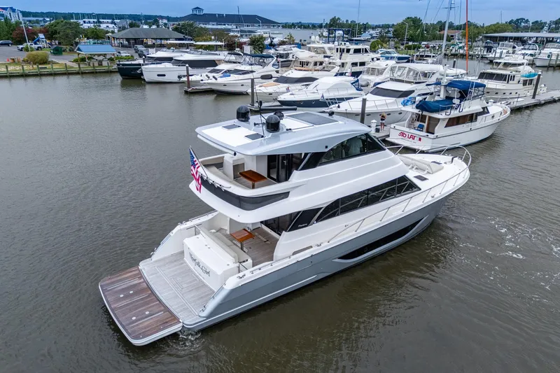 Slide: The Image of 2023 Maritimo M55 yacht docked at a marina, surrounded by other boats. - 8