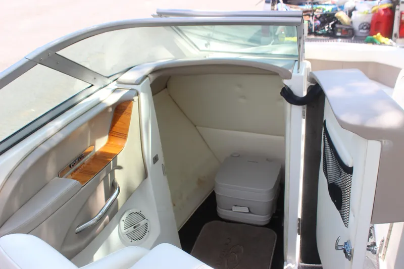 Slide: The Image of Interior of a 2006 Cobalt 246 boat featuring a compact cabin with a portable toilet. - 1