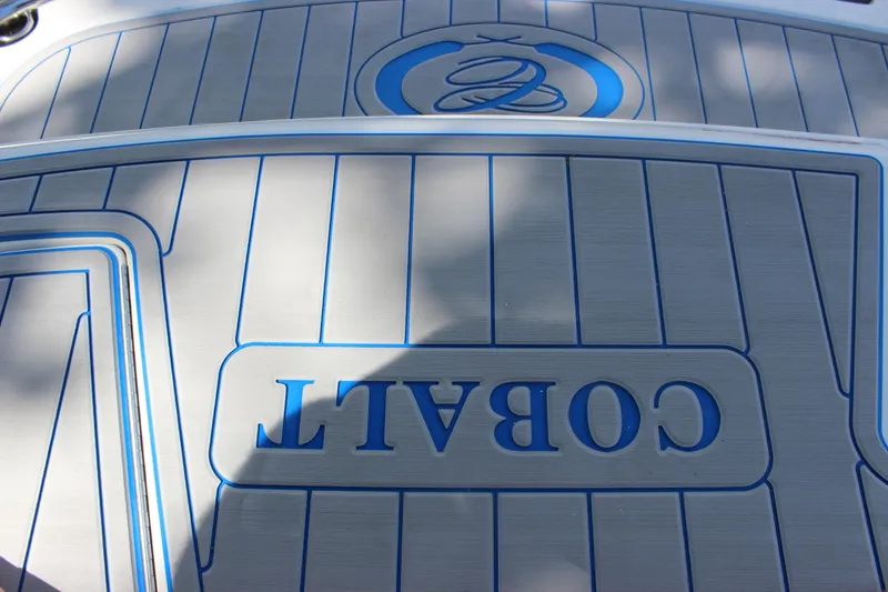 Slide: The Image of 2006 Cobalt 246 boat deck with logo and blue accents. - 13