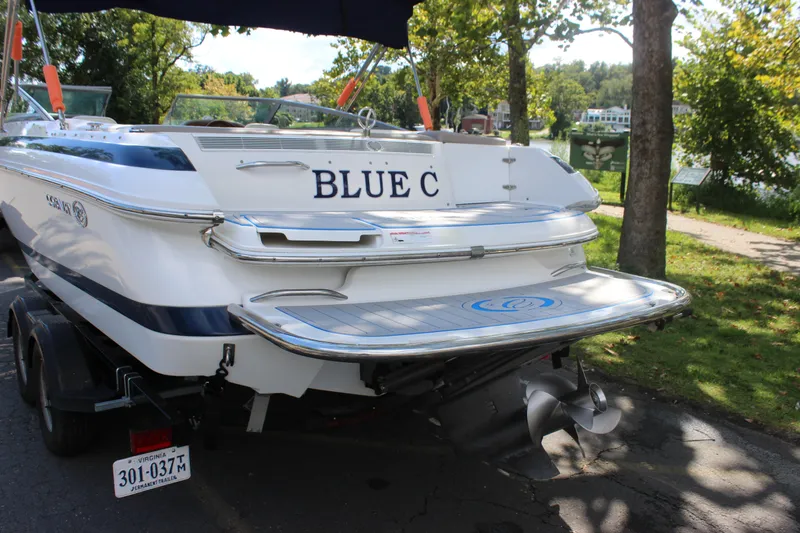 Slide: The Image of 2006 Cobalt 246 boat named "Blue C" on trailer, parked near a lake. - 24