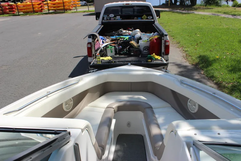 Slide: The Image of 2006 Cobalt 246 boat interior with truck bed full of gear, near colorful kayaks. - 4