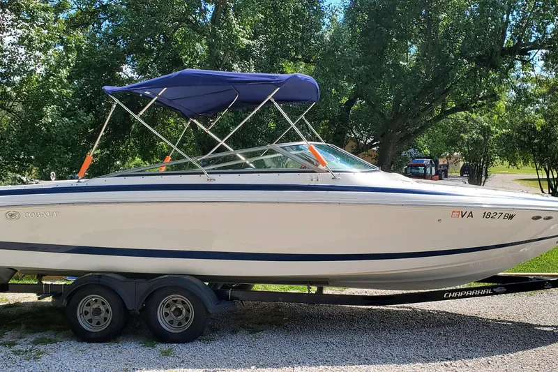 Slide: The Image of 2006 Cobalt 246 boat on trailer with blue canopy, parked outdoors. - 40