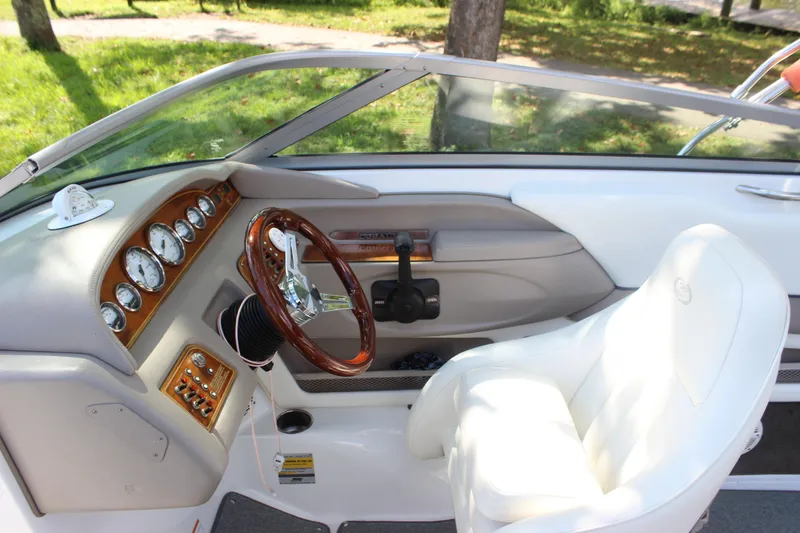 Slide: The Image of Interior of a 2006 Cobalt 246 boat with white seating and wooden dashboard. - 5