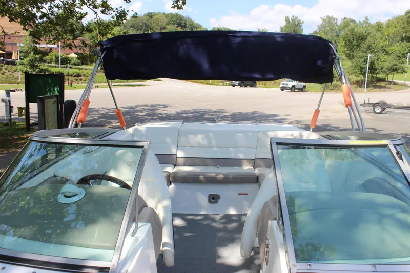Slide: The Image of 2006 Cobalt 246 boat with canopy, parked in a sunny outdoor setting. - 8