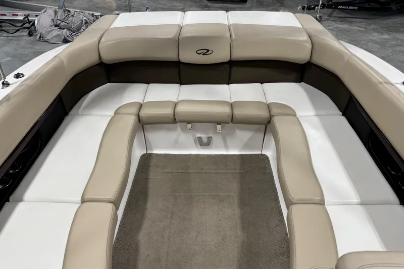 Slide: The Image of 2012 Regal 2700 Bowrider interior with beige and white seating, carpeted floor. - 10