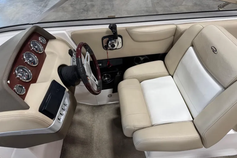 Slide: The Image of 2012 Regal 2700 Bowrider cockpit with beige seating and instrument panel. - 8