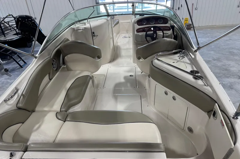 Slide: The Image of 2005 Sea Ray 240 Sundeck interior with beige seating and steering console. - 6