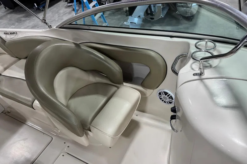 Slide: The Image of 2005 Sea Ray 240 Sundeck interior with beige seating and cup holders. - 8