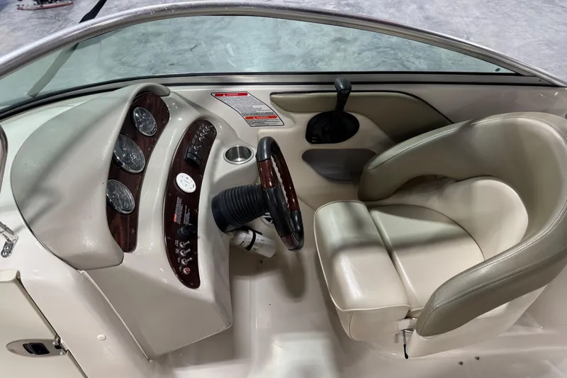 Slide: The Image of 2005 Sea Ray 240 Sundeck helm with beige seating and instrument panel. - 9