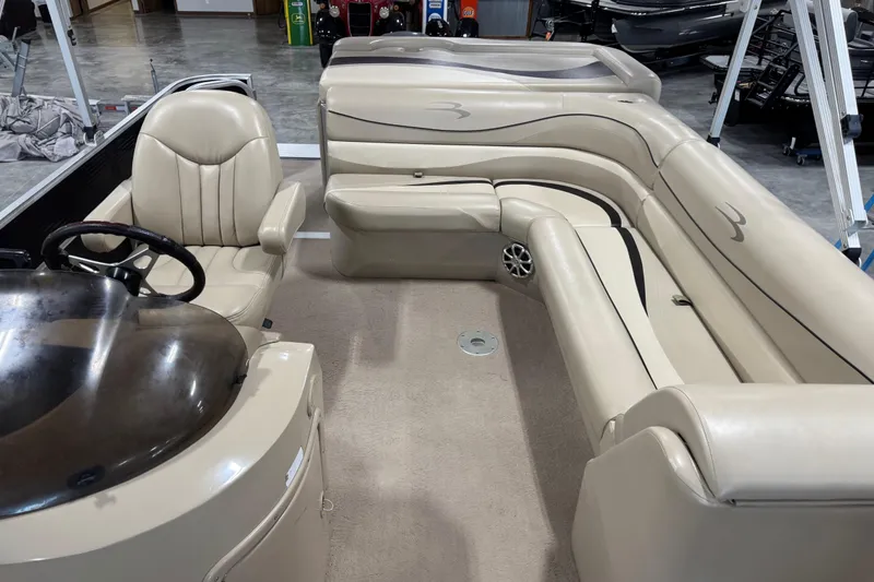 Slide: The Image of 2010 Bennington 2574GLi boat interior with beige seating and steering console. - 11