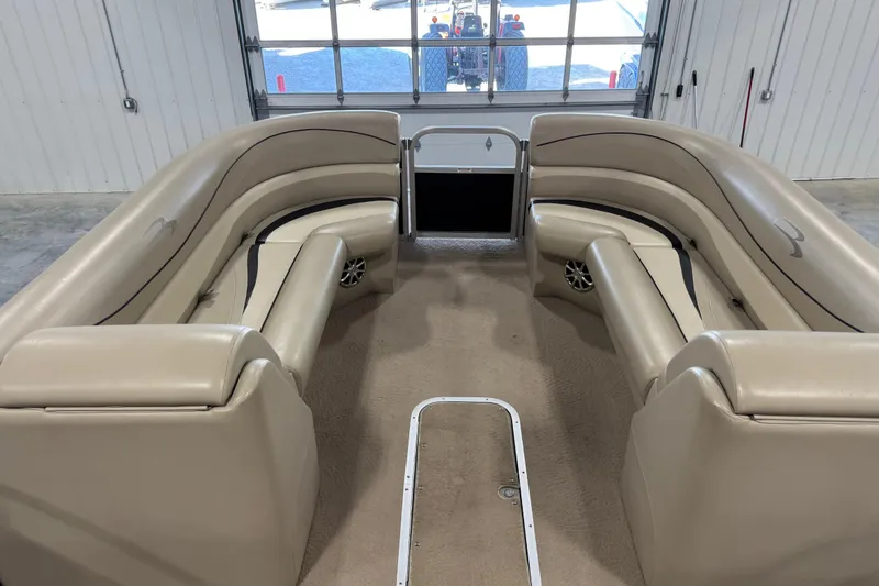 Slide: The Image of 2010 Bennington 2574GLi boat interior with beige seating and carpeted floor. - 13