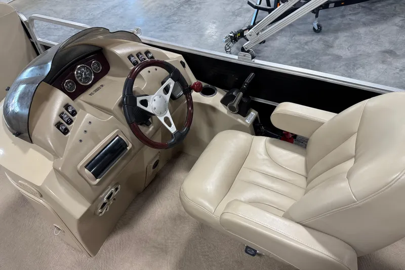 Slide: The Image of 2010 Bennington 2574GLi boat dashboard with steering wheel and beige captain's chair. - 14